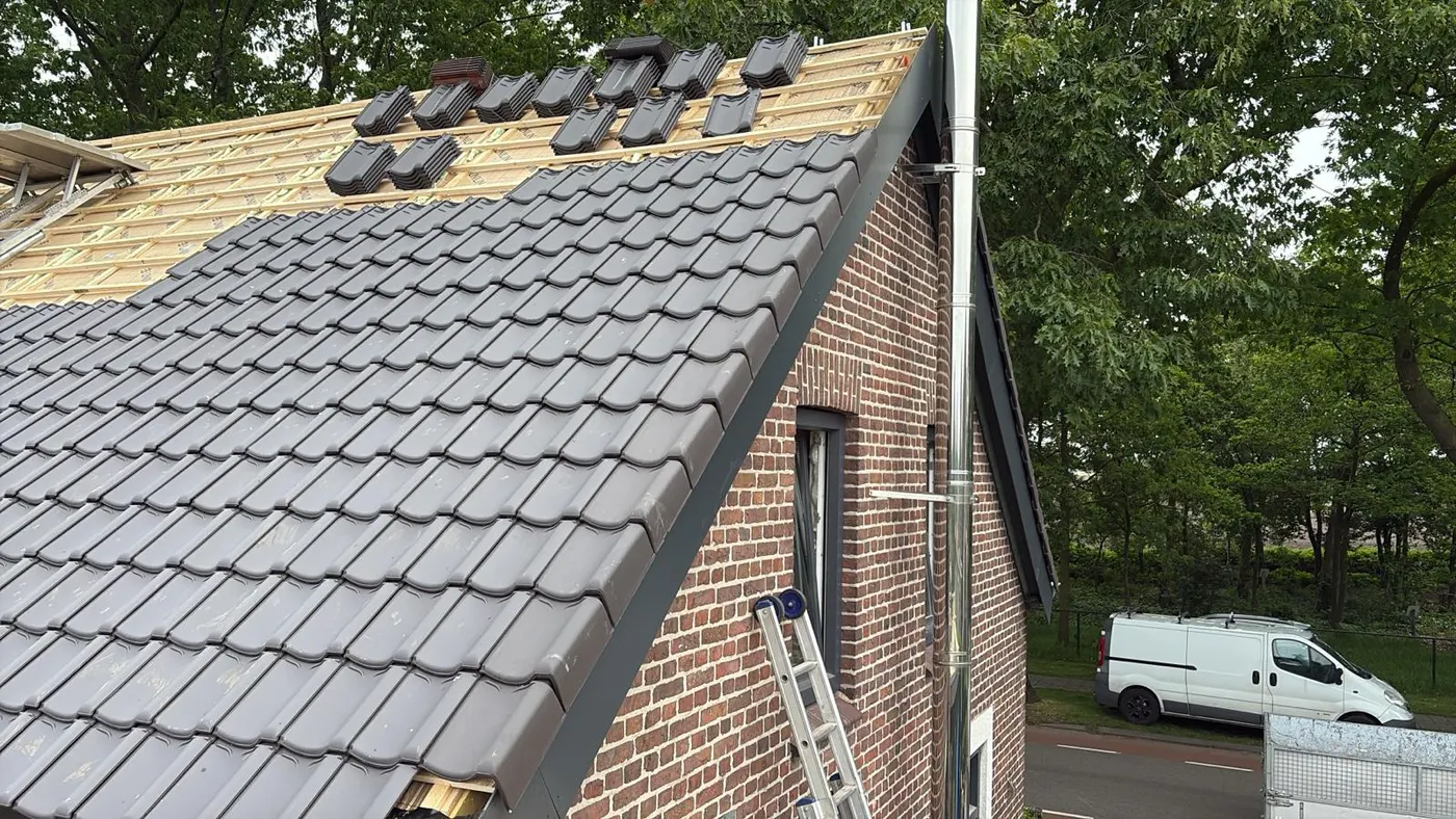 Nieuwe dakpannen worden gelegd op een pannendak door Oosterhout Dakonderhoud